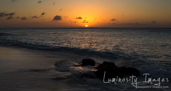 Sunset over Caribbean ocean with reflections in tidal pool.Bonai