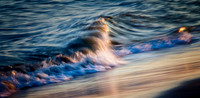 Reflected sunset light off wave hitting beach.Baldhead NC