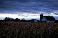 Stormy sky over farm and cornfield. IL.